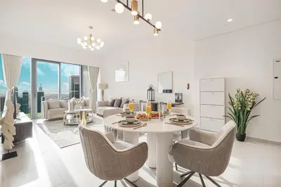 a kitchen and living room with a table and chairs at Luxury Grande Suites by Hostiva - Full City View in Dubai