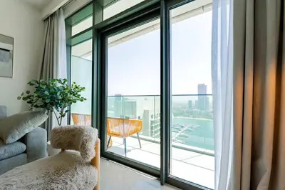 a living room with a large window and a chair at TRPS - Beach Vista, Dubai Harbour - Ain Dubai View, Furnished, Private Beach Access in Dubai
