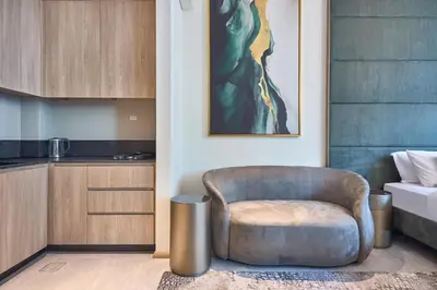 a living room with a chair and a kitchen at Luxury-Comfort & Elegance Studio in Dubai