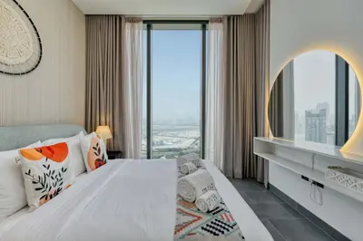 a bedroom with a bed and a large window at PVH Stylish Boho 1BR with Study - The Crest in Dubai