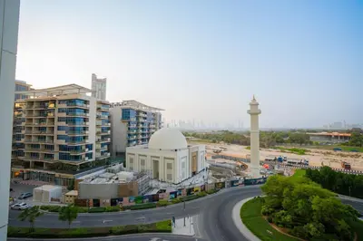 a view of a city with a mosque and a clock tower at Crest Serene Stay for 4 Guests 1BR and Cozy Room in Dubai