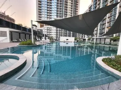 a large swimming pool in a city with tall buildings at Crest Serene Stay for 4 Guests 1BR and Cozy Room in Dubai