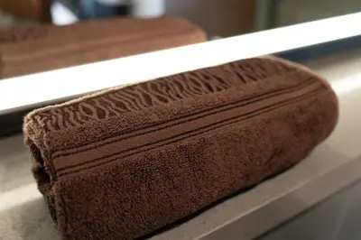 a brown towel sitting on a counter in front of a mirror at Crest Serene Stay for 4 Guests 1BR and Cozy Room in Dubai