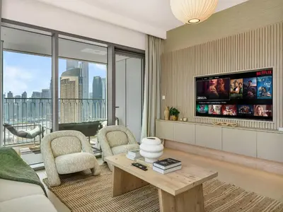 a living room with a couch and a tv at Downtown 4BDR Apartment Opposite Dubai Mall, Burj Khalifa Views in Dubai