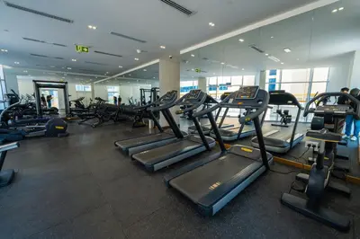 a gym with rows of treadmills and elliptical machines at Burjkhalifa View Top Floor Dubai Mall 7Mins in Dubai