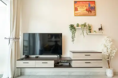 a living room with a flat screen tv on a wall at Burjkhalifa View Top Floor Dubai Mall 7Mins in Dubai