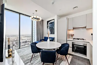 a kitchen and dining room with a table and chairs at Fancy 1BR apartment The Crest at Sobha Hartland in Dubai