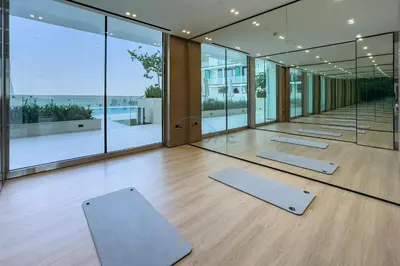 a row of yoga mats in a room with windows at Studio Just Minutes Drive from Miracle Garden, Near Local Parks and Circle Mall, Binghatti Azure, JVC by Deluxe Holiday Homes in Dubai