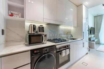 a kitchen with a microwave and a dishwasher at Studio Just Minutes Drive from Miracle Garden, Near Local Parks and Circle Mall, Binghatti Azure, JVC by Deluxe Holiday Homes in Dubai