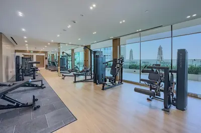 a gym with treadmills and cardio equipment in a building at Studio Just Minutes Drive from Miracle Garden, Near Local Parks and Circle Mall, Binghatti Azure, JVC by Deluxe Holiday Homes in Dubai