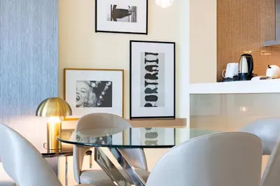 a dining room with a glass table and white chairs at TRPS - Paramount Tower D, Business Bay - Premium 1BR Furnished, High Floor, Ready Move In in Dubai