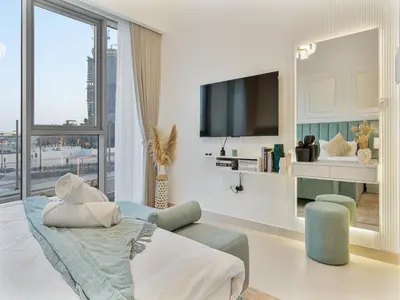 a living room with a tv and a couch at Savis Homes - Canal Front Residence Near Al Wasl Safa Park with Skyline View in Dubai