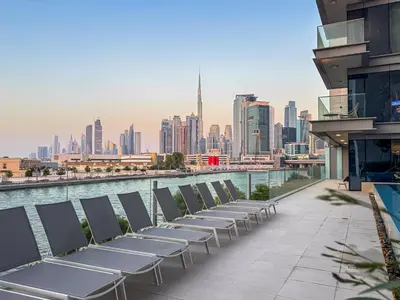 a row of tables and chairs on a building overlooking a city at Savis Homes - Canal Front Residence Near Al Wasl Safa Park with Skyline View in Dubai