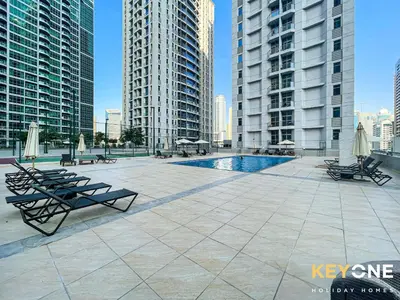 a patio with chairs and a pool in a city at Magnificent Two Bedroom Beachfront in Dubai