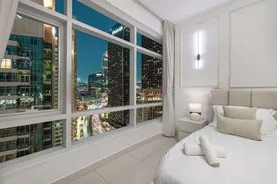 a bedroom with a large window with a city view at Luxe 2 Bed with Burj View, 5 Min Walk to Dubai Mall, PS5 by Vista Stays Dubai Downtown in Dubai