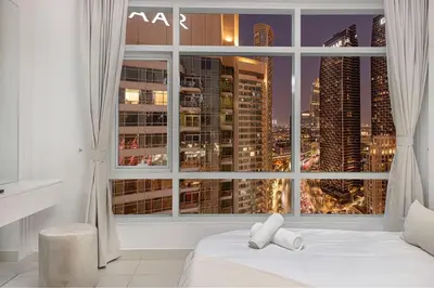 a bedroom with a large window with a city view at Luxe 2 Bed with Burj View, 5 Min Walk to Dubai Mall, PS5 by Vista Stays Dubai Downtown in Dubai