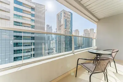 a balcony with two chairs and a view of the city at Easy Metro and Tram Access 1BR, Offering Partial Canal, SZR, and City Views, Just Minutes from Marina Mall, Marina Diamond 6, Dubai Marina by Deluxe Holiday Homes in Dubai