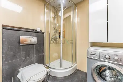a bathroom with a toilet and a shower and a washing machine at Easy Metro and Tram Access 1BR, Offering Partial Canal, SZR, and City Views, Just Minutes from Marina Mall, Marina Diamond 6, Dubai Marina by Deluxe Holiday Homes in Dubai