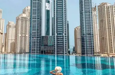a woman in a pool in a city with tall buildings at Daniels 1BR at JW Marriott with Marina View in Dubai