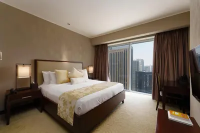 a hotel room with a bed and a large window at Daniels 1BR at JW Marriott with Marina View in Dubai