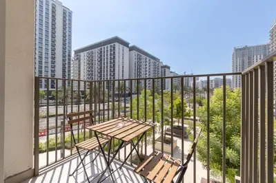 a balcony with a table and chairs and buildings at StayShort - Dubai Hills sleeps 4 in a Great Location in Dubai
