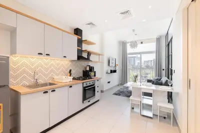 a kitchen with white cabinets and a counter top at StayShort - Dubai Hills sleeps 4 in a Great Location in Dubai