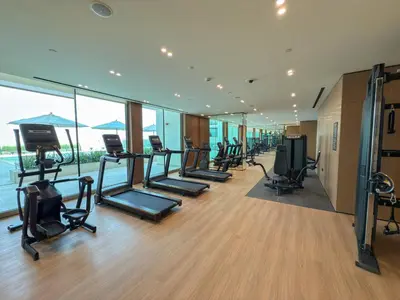 a gym with a row of treadmills and exercise equipment at luxury Madrid Studio-Binghatti Azure in Dubai