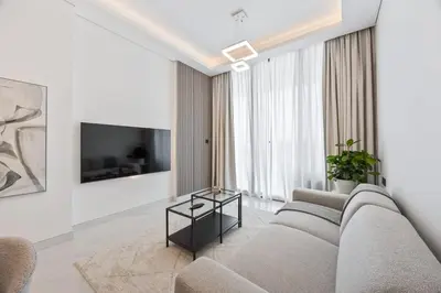 a living room with a couch and a tv at 2 bedroom apartment with private pool in Dubai