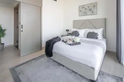 a bedroom with a large white bed with white sheets at Frank Porter - Binghatti Corner in Dubai