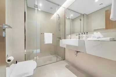 a bathroom with a shower and a toilet and a sink at Partial Canal View 2BR plus Maid close to Safa Park in Dubai