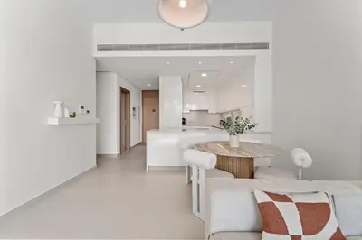 a kitchen and living room with a table and a couch at Partial Canal View 2BR plus Maid close to Safa Park in Dubai