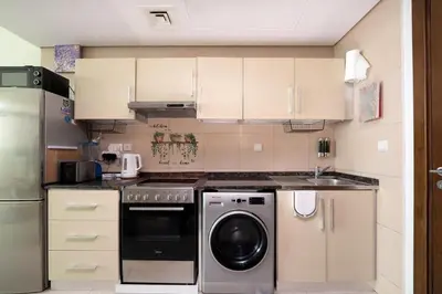 a kitchen with a washing machine and a sink at Fully Furnished Studio Hilliana Tower Sea View and Burj View in Dubai