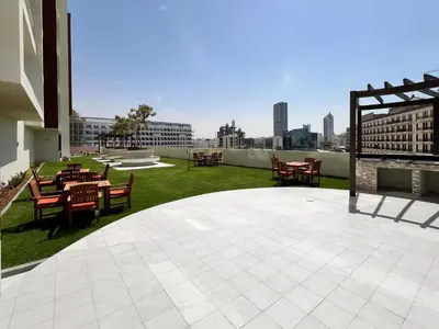 a patio with tables and chairs on top of a building at Frank Porter - Jwelz Residence in Dubai