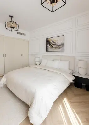 a white bedroom with a large bed and a chandelier at Spacious and luxurious 1 bed with amazing marina view!Rimal ! in Dubai
