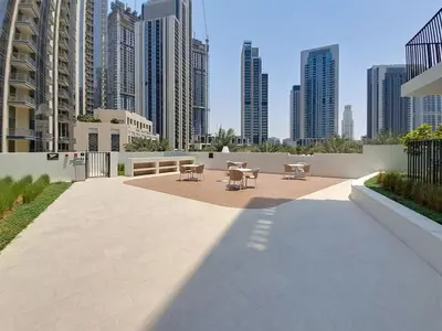 a patio with tables and chairs in a city with tall buildings at Vacationer l Chic 2 Bedroom l Prime Location in Creek Harbour l Pool View in Dubai