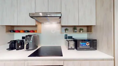 a kitchen with a sink and a microwave at Vacationer l Modern 1 Bedroom l Aesthetic Interior l Free Wi-Fi in Dubai