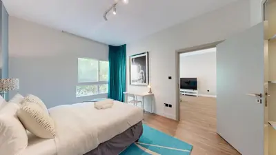 a bedroom with a white bed and a blue wall at Vacationer l Modern 1 Bedroom l Aesthetic Interior l Free Wi-Fi in Dubai