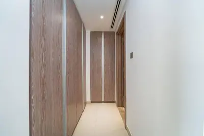 a hallway with wood paneled walls and a long corridor at Waterfront Living Bright 1 Bedroom Marina in Dubai