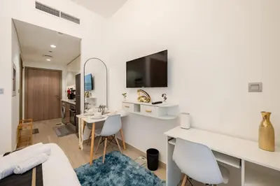a white living room with a table and chairs at Ramora Homes Azizi Riviera 40 by Vacay Xeal in Dubai