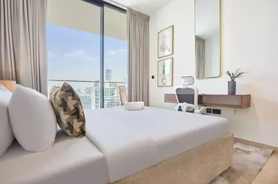 a large white bed in a room with a large window at Modern 1BR Urban Escape at Blue Paradise in Dubai
