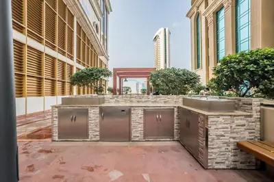 a kitchen with two sinks on a patio next to a building at Sky-Level 2BR with Partial Marina View, Just Steps to Dubai Tram and Minutes from the Beach, Elite Residence, Dubai Marina by Deluxe Holiday Homes in Dubai