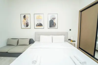 a bedroom with a white bed and a couch at AWS Holiday Homes - Iconic Burj Khalifa Views in Dubai