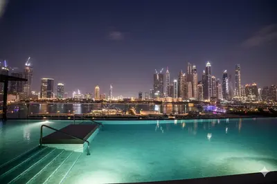 a view of a city skyline at night at Private Beach , Luxury 2BR , Emaar 5-Star Amenities in Dubai