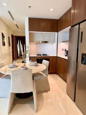 a kitchen with a table and chairs and a refrigerator at Private Beach , Luxury 2BR , Emaar 5-Star Amenities in Dubai