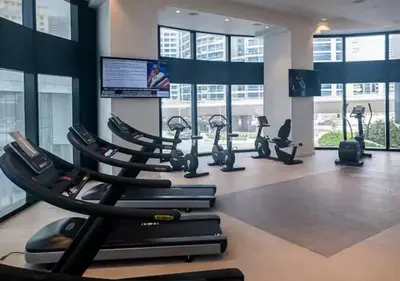 a gym with a row of treadmills and ellipticals at Exclusive 2BD in JBR Address with Ain Dubai View in Dubai