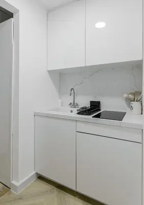a white kitchen with white cabinets and a sink at Spacious and luxurious studio with amazing marina view!Rimal ! in Dubai