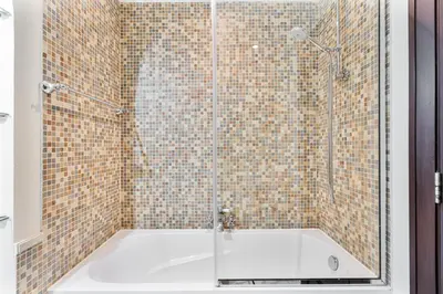 a bathroom with a shower with a bath tub at 2BHK Downtown Breathtaking Burj Khalifa View in Dubai