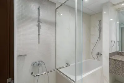a bathroom with a shower with a glass door at The Rosewood HH at Sarai Residence, Palm Jumeirah, 5 mins from the Iconic Atlantis The Royale in Dubai