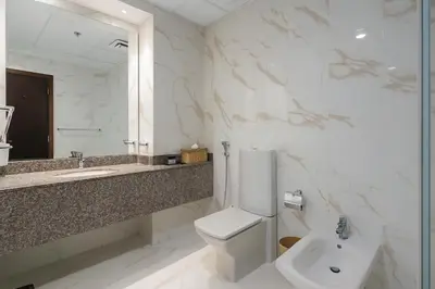 a bathroom with a toilet and a sink and a mirror at The Rosewood HH at Sarai Residence, Palm Jumeirah, 5 mins from the Iconic Atlantis The Royale in Dubai