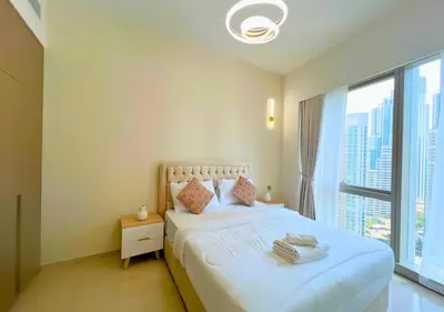 a bedroom with a white bed with a large window at DreamShoma Grande Signature Luxury Full Burj Khalifa & Fountain View in Dubai